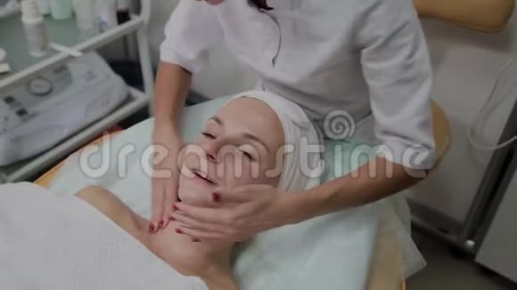 专业美容师给女孩脸上涂保湿霜视频的预览图