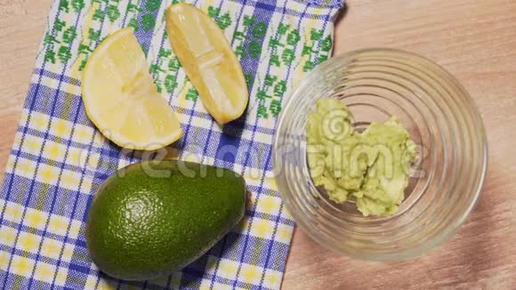 停止运动在背景中用透明的碗鳄梨和柠檬填充鳄梨酱美味可口的墨西哥美食视频的预览图