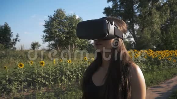 年轻女子使用头戴式户外显示器玩游戏使用VR头盔智能手机视频的预览图