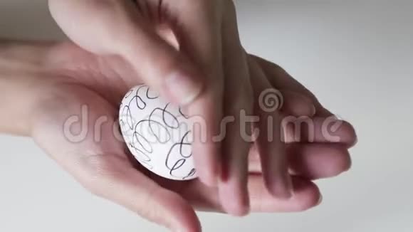 无法辨认的女人手里拿着一个图案的鸡蛋复活节彩蛋复活节假期的概念双手视频的预览图