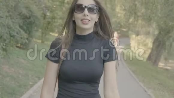 少年女子戴着眼镜在公园散步视频的预览图