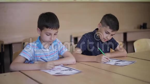 男孩和女孩坐在桌子上写着一篇文章视频的预览图