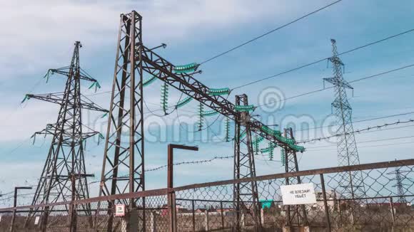 高压电气变电站带绝缘子的柱头和防护栅栏后面的电线电力和电力视频的预览图