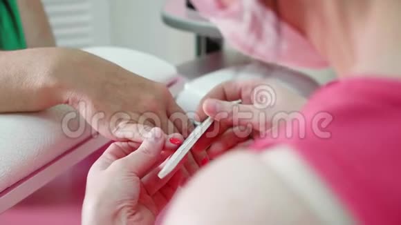 女性手部美甲近景在修指甲的过程中一只年老的女士手视频的预览图
