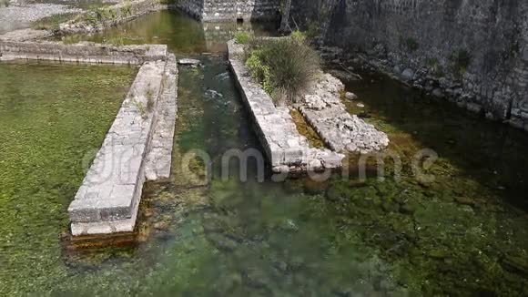 拥有护城河的Kotor黑山堡垒墙护城河溪中的绿色清水从石头中获得强化堡垒视频的预览图