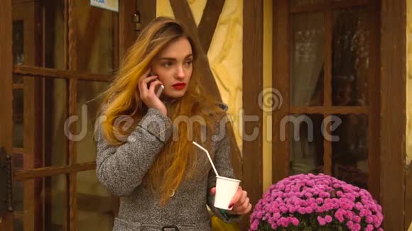 红头发的女孩在街上喝咖啡视频的预览图
