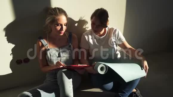 两个女孩在工地上讨论为他们的公寓选择壁纸视频的预览图