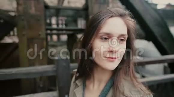 一位美丽的年轻女子站在一个古老的乡村水磨厂附近对着镜头微笑视频的预览图