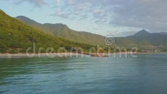 飞越海的飞碟靠近海岸和绿山视频的预览图