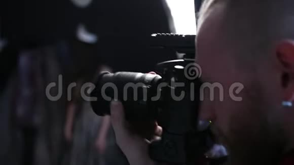 在摄影棚里一名摄影师用一台专业照相机拍照视频的预览图