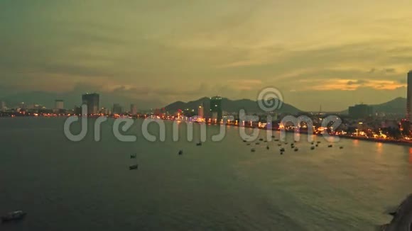 在日落的时候无人机在海边展示傍晚的城市视频的预览图