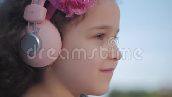 一个留着卷发的可爱孩子的肖像一个穿着粉红色衣服的白种人小女孩头上戴着一朵粉红色的花视频的预览图