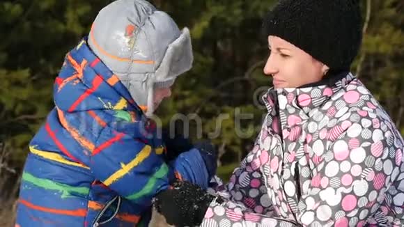 快乐的母亲和她的孩子在冬天的森林里视频的预览图