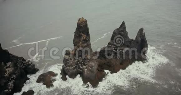 在冰岛鸟瞰群山匍匐在地有海鸥筑巢直升机在黑色海滩的悬崖上飞行视频的预览图