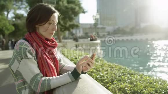 美丽的女人站在贝拉焦的喷泉前发短信视频的预览图