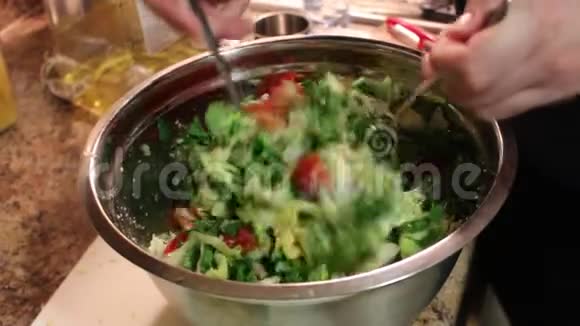 女性手在厨房里搅拌新鲜蔬菜沙拉和奶酪Feta蔬菜的混合特写视频的预览图