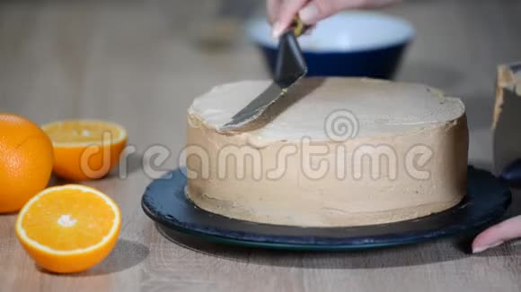 糖果师把奶油放在蛋糕的顶部面包师平滑蛋糕与奶油糖霜视频的预览图