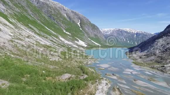 在阳光明媚的一天里在挪威的尼加兹瓦特涅约斯特达尔斯布雷恩国家公园内的尼加兹布雷恩冰川附近的鸟瞰图视频的预览图