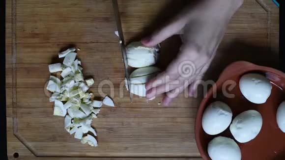 在木桌上用刀把鸡蛋切成小块视频的预览图