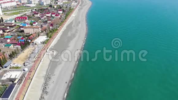 人们在海滩和大海上尽情放松的鸟瞰从飞行无人机俯视视频的预览图