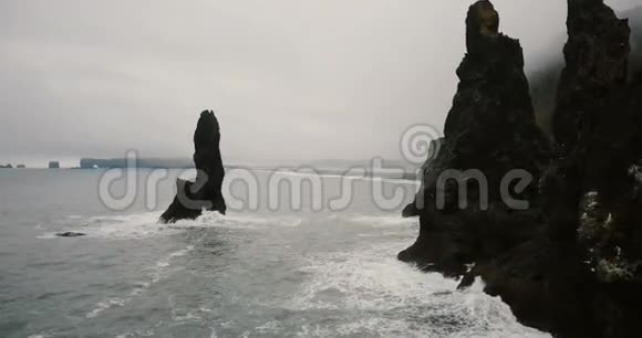 冰岛的黑色火山海滩和巨怪脚趾岩石的空中景色海鸥靠近直升机飞行视频的预览图