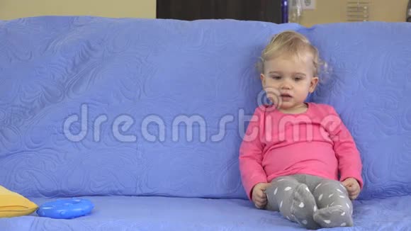 柔软的玩具雨落在可爱的金发女孩坐在沙发上孩子的梦想成真了视频的预览图