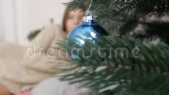 那个女孩躺在圣诞树背景上的床上新年视频的预览图