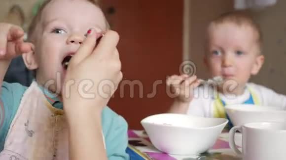 两兄弟在家和妈妈一起吃粥他们坐在家里的一张小桌子上用勺子吃饭视频的预览图