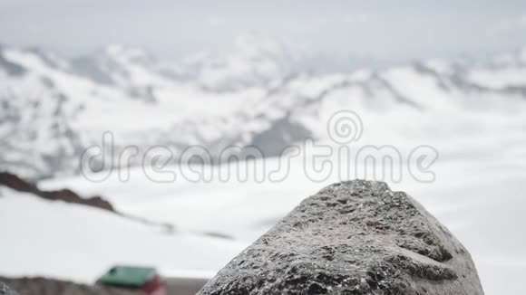 雪山景色下徒步旅行者穿着皮鞋踩在石头上视频的预览图