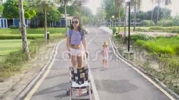 戴墨镜的女人和婴儿车一起走视频的预览图