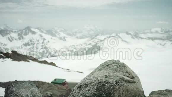 在雪山风景名胜区的岩石上踩着皮鞋的旅行者的脚视频的预览图