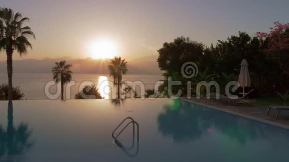 度假场景游泳池可在日落时俯瞰大海和山脉视频的预览图