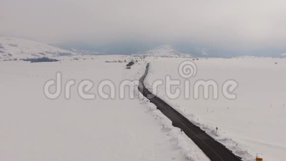 漫长的道路绵延穿过白雪皑皑的风景视频的预览图