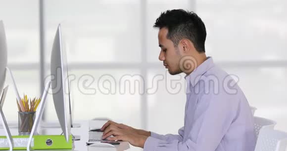 亚洲商人在电脑键盘上打字视频的预览图