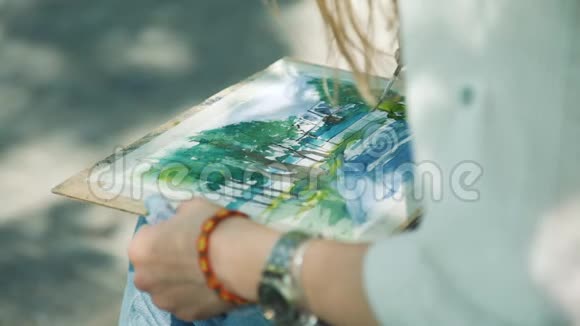 女艺术家画一幅堤岸画视频的预览图