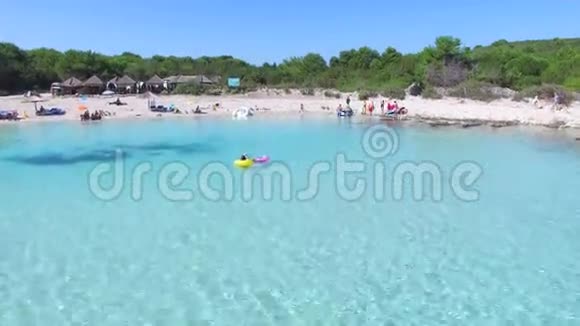 人们在沙滩上用阳伞游泳和日光浴视频的预览图