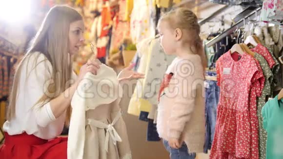 金发女人带着小女儿买孩子的衣服视频的预览图