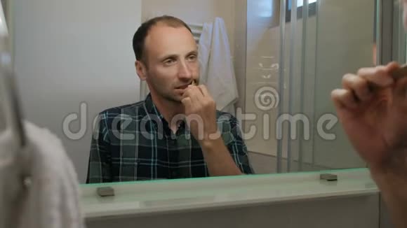 年轻人在室内站在浴室里刷牙视频的预览图