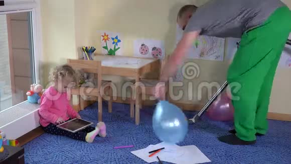 男胡佛儿童房和小女孩坐在地上玩平板电脑视频的预览图