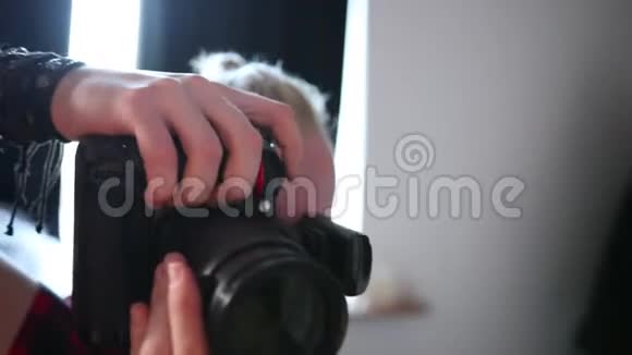 在摄影棚里一名摄影师用一台专业照相机拍照视频的预览图