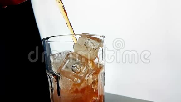 将橙色饮料酒精鸡尾酒倒入杯中杯中有黑色背景的冰块视频的预览图