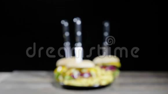 把注意力从家庭制作的汉堡和薯条放在黑色背景的木桌上放大视频的预览图