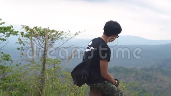 亚洲男人坐在木椅上从山顶拍照庞思达国家公园视频的预览图