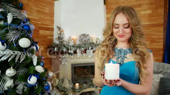 快乐的女孩吹着燃烧的蜡烛女孩和蜡烛一个年轻女子的画像手里拿着一支白色的蜡烛女孩视频的预览图