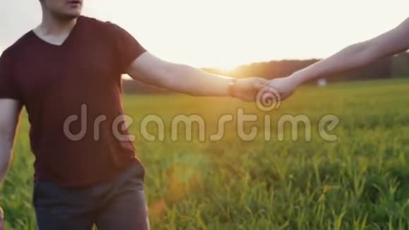 两人在日落时散步在一个美丽的地方牵手太阳光从树顶照射出来慢莫稳定射击视频的预览图