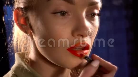 美丽的女孩把嘴唇涂成红色铅笔视频的预览图