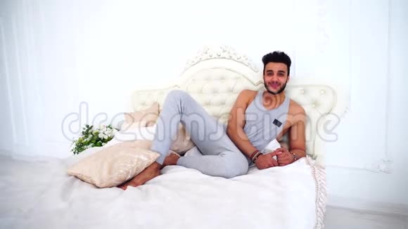 阿拉伯射击男子肖像微笑和良好的心情在床上在明亮的卧室视频的预览图