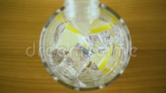 柠檬水倒入一个玻璃与冰顶视图慢节奏视频的预览图
