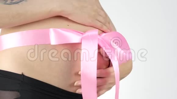 怀孕的女人肚子上有一条粉红色的丝带4K视频的预览图
