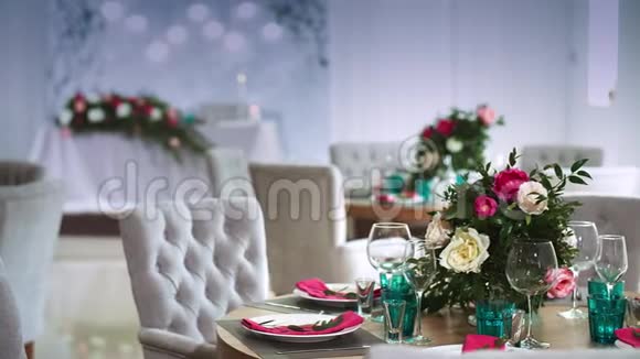 一张圆形的木制桌子上面装饰着由白色盘子和粉色餐巾纸做成的花饰视频的预览图